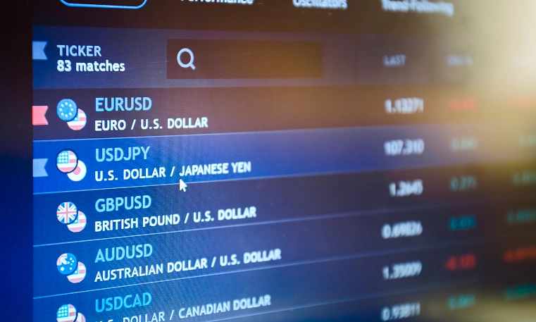 Monitor showing major currency pairs for forex day trading, like EUR/USD and USD/JPY.